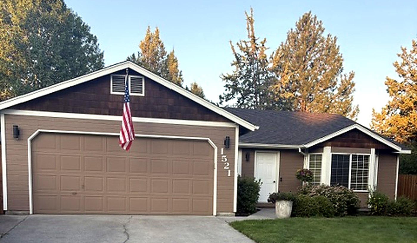 The front of the house on NE Locksley Drive: a single-storey home with a two-car garage and the number 1521 beside the front door.